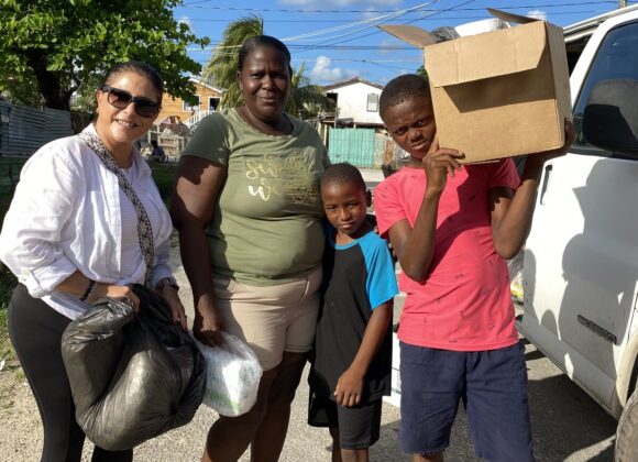 A Build Belize volunteer delivering boxed relief supplies to a family